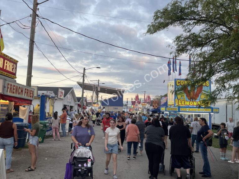 Visitors stroll through the busy midway, soaking in the sights, sounds, and the smells of the Allen County Fair